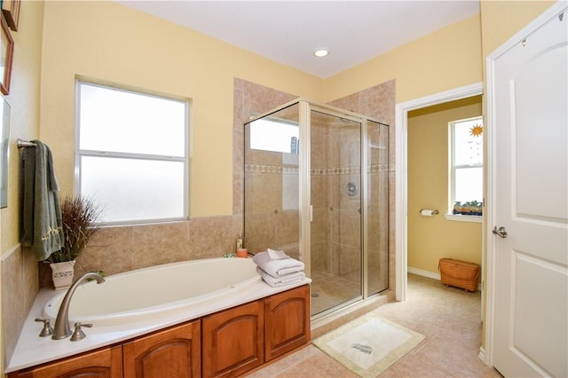 bathroom with a stall shower and a garden tub