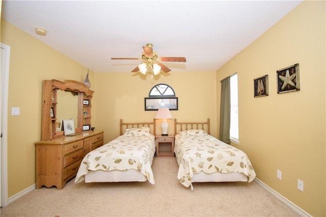 bedroom with light carpet, ceiling fan, and baseboards