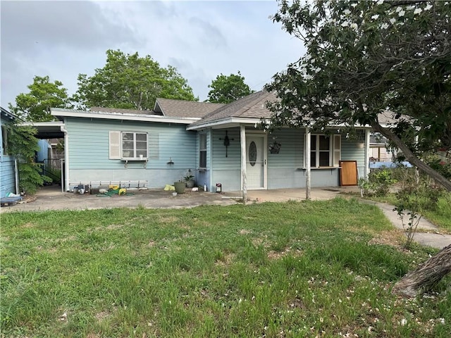 single story home with a patio area, roof with shingles, and a front yard