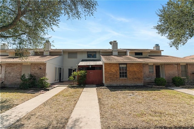 view of front facade featuring brick siding and a front lawn