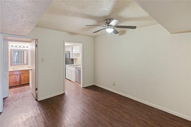 unfurnished bedroom with a textured ceiling, ceiling fan, connected bathroom, dark wood-style flooring, and baseboards