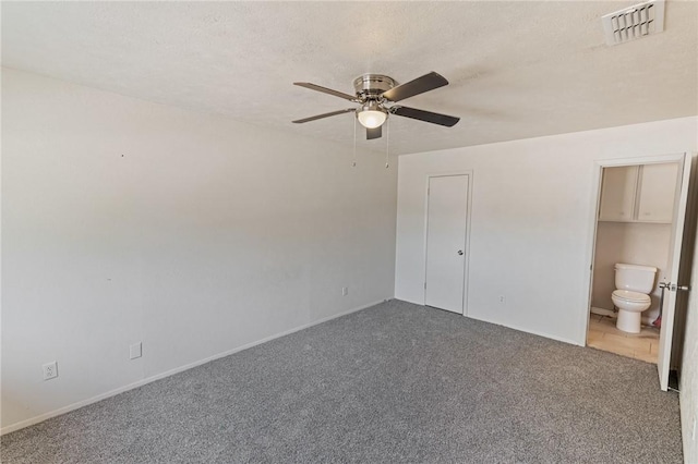 unfurnished bedroom featuring visible vents, connected bathroom, ceiling fan, carpet, and a textured ceiling