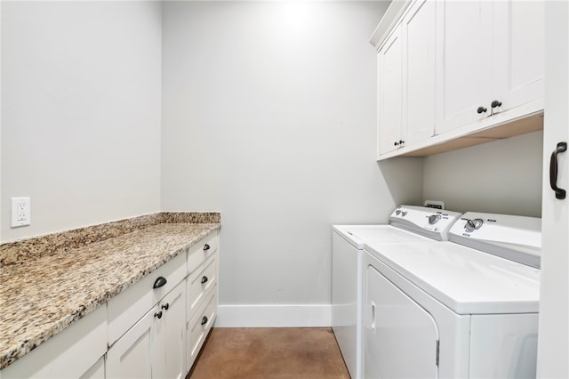 clothes washing area featuring washing machine and dryer and cabinets