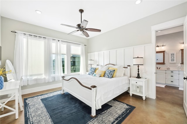 bedroom with concrete flooring, ceiling fan, and ensuite bath