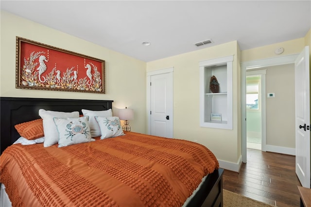 bedroom with dark hardwood / wood-style flooring