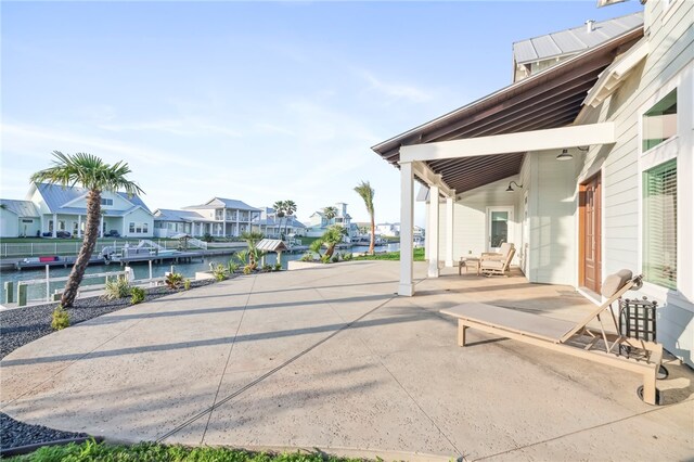 view of patio featuring a swimming pool, a water view, and a dock