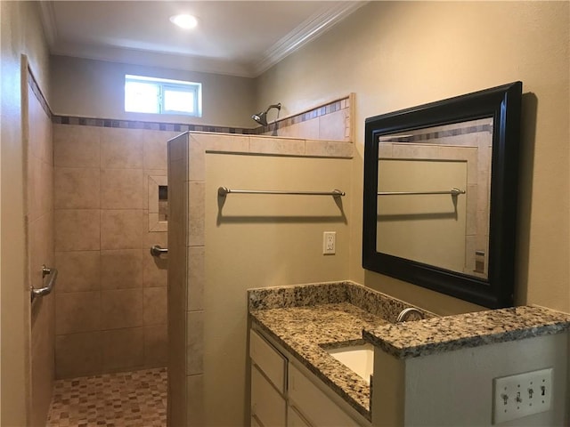 bathroom featuring vanity, tiled shower, and crown molding