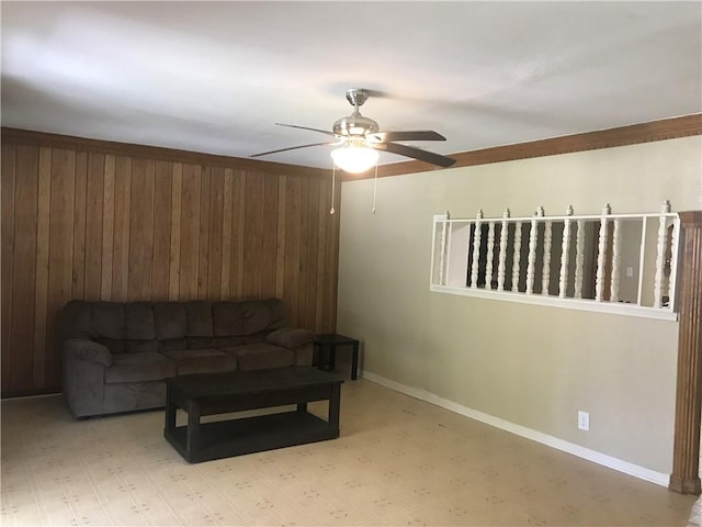 living room with ceiling fan and wood walls