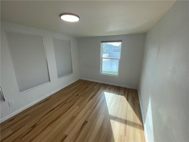 empty room featuring baseboards and wood finished floors