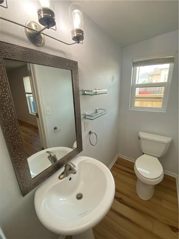 bathroom with a sink, baseboards, toilet, and wood finished floors