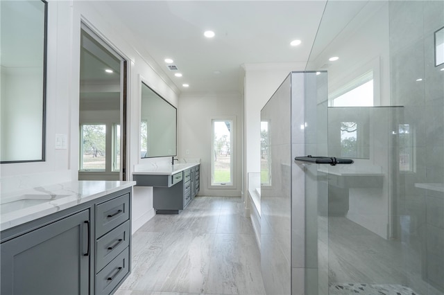 full bathroom with two vanities, recessed lighting, tiled shower, and ornamental molding