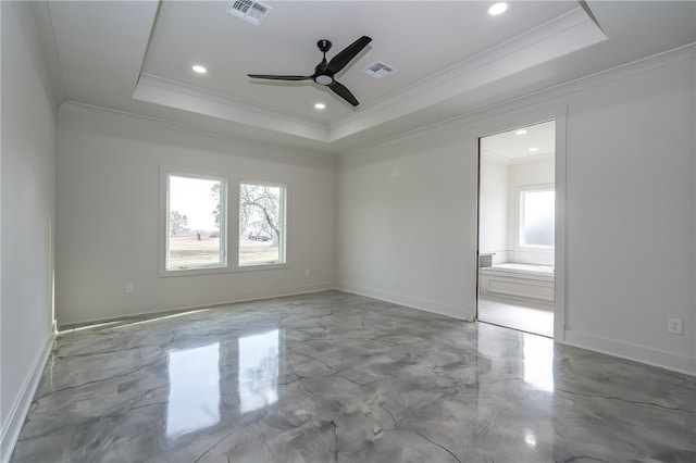 spare room featuring plenty of natural light, visible vents, and a tray ceiling