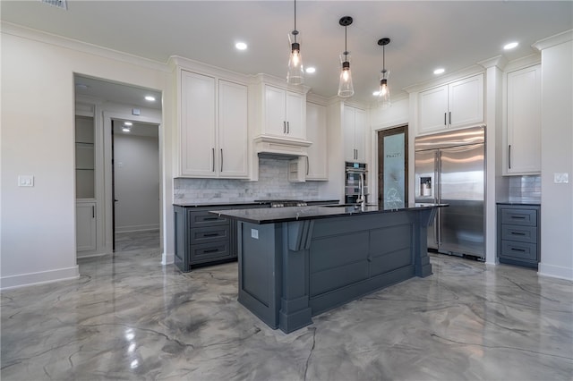 kitchen with decorative backsplash, stainless steel appliances, white cabinetry, and an island with sink