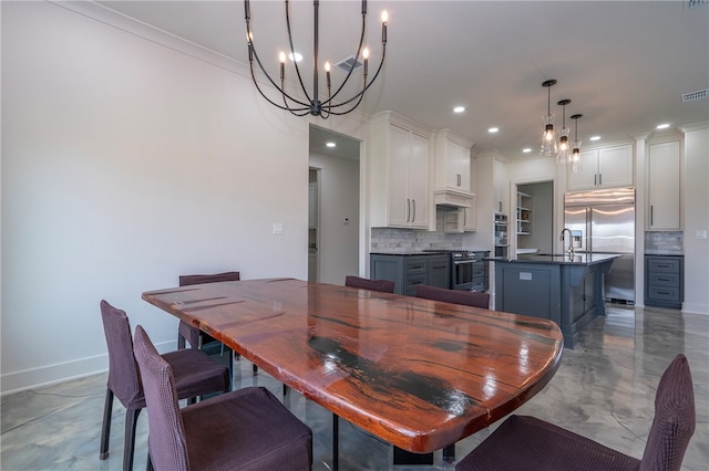 dining room with crown molding, sink, and a chandelier