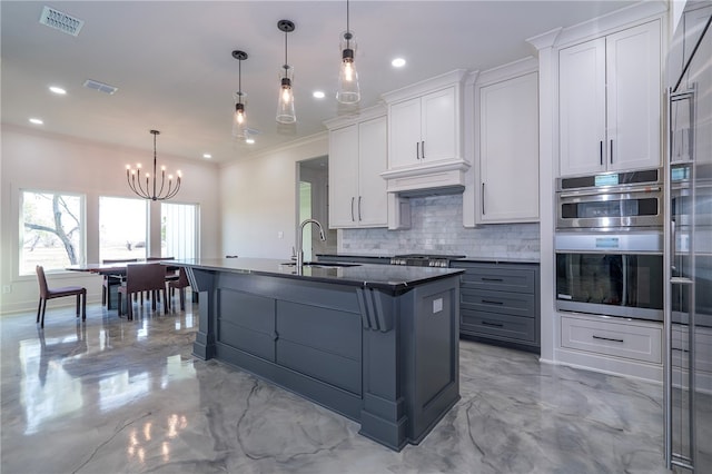 kitchen featuring white cabinets, a notable chandelier, sink, and tasteful backsplash