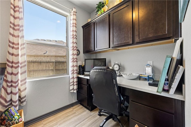 office space with light wood finished floors and built in desk