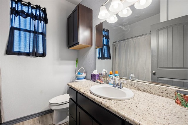 bathroom with vanity, a shower with curtain, wood finished floors, baseboards, and toilet