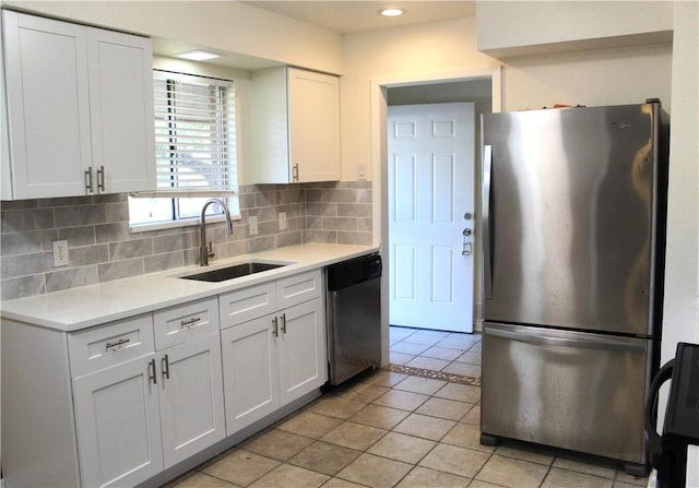 kitchen featuring white cabinetry, stainless steel appliances, sink, and backsplash