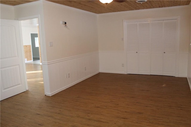 spare room featuring ornamental molding, dark hardwood / wood-style floors, wooden ceiling, and ceiling fan