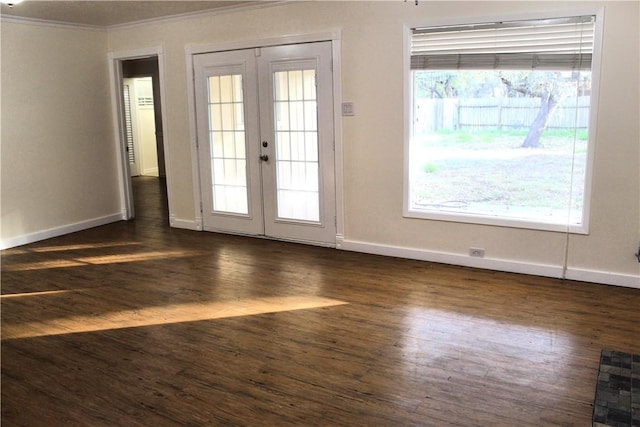 empty room featuring french doors, ornamental molding, and dark hardwood / wood-style flooring