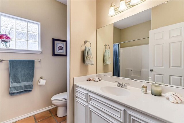 13530 Royal Fifth Ct, Corpus Christi, TX 78418 - bathroom featuring tile patterned flooring, baseboards, toilet, vanity, and a shower with curtain