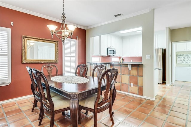 13530 Royal Fifth Ct, Corpus Christi, TX 78418 - dining room with a chandelier, crown molding, baseboards, and light tile patterned floors