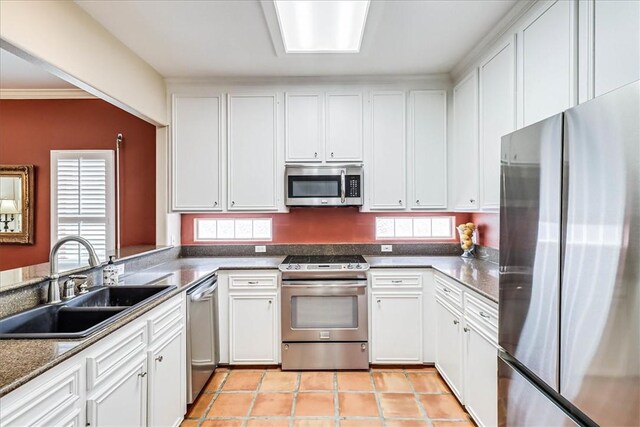 13530 Royal Fifth Ct, Corpus Christi, TX 78418 - kitchen featuring stainless steel appliances, a sink, white cabinets, light tile patterned floors, and crown molding