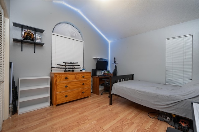 bedroom with light hardwood / wood-style flooring and lofted ceiling