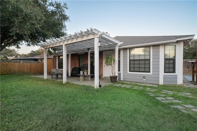 rear view of house featuring a pergola, a lawn, and a patio