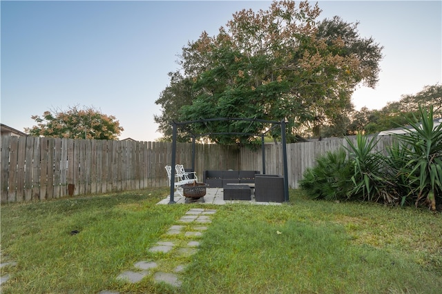 view of yard with an outdoor living space with a fire pit