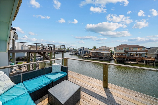 dock area featuring an outdoor living space and a deck with water view