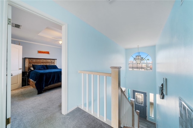 hall featuring ornamental molding, light colored carpet, and an inviting chandelier