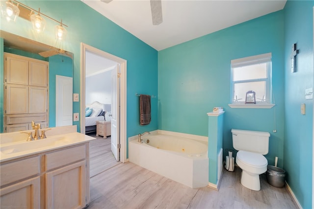 bathroom with vanity, hardwood / wood-style flooring, toilet, and a bathtub