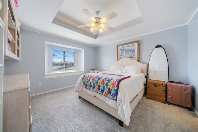 bedroom featuring light carpet, a tray ceiling, and ceiling fan