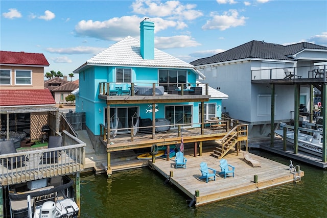 back of property with a water view and a balcony