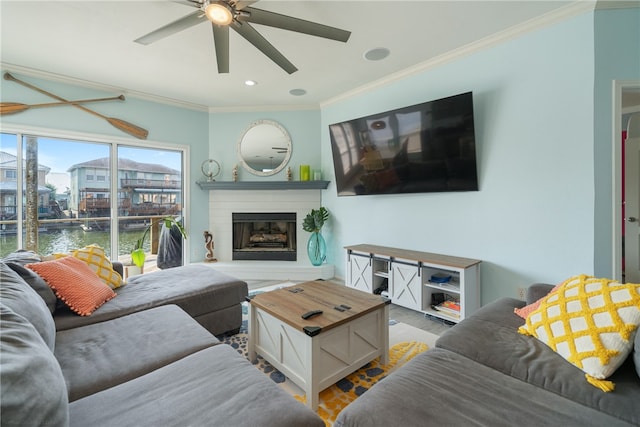 living room with ceiling fan, a water view, and crown molding