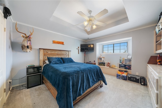 bedroom featuring a raised ceiling, ceiling fan, light colored carpet, and ornamental molding