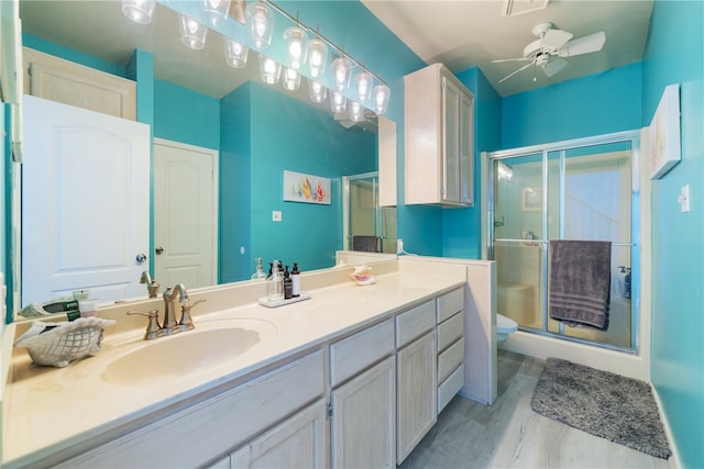 bathroom with hardwood / wood-style flooring, a shower with door, and ceiling fan