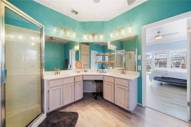 bathroom with a shower with shower door, ceiling fan, wood-type flooring, and vanity