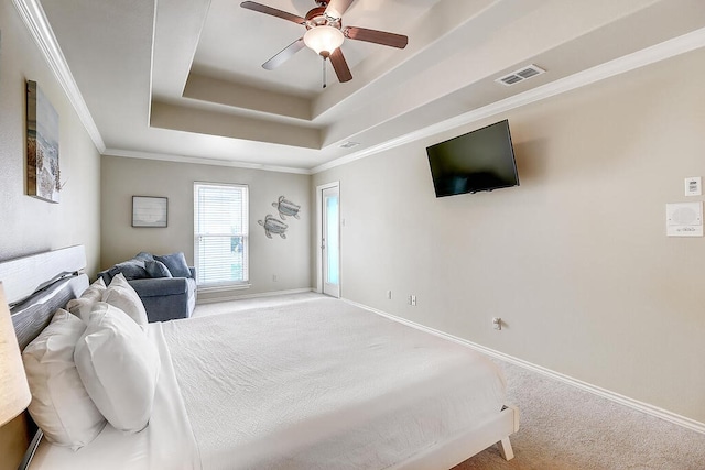 bedroom with ceiling fan, a tray ceiling, ornamental molding, and carpet flooring