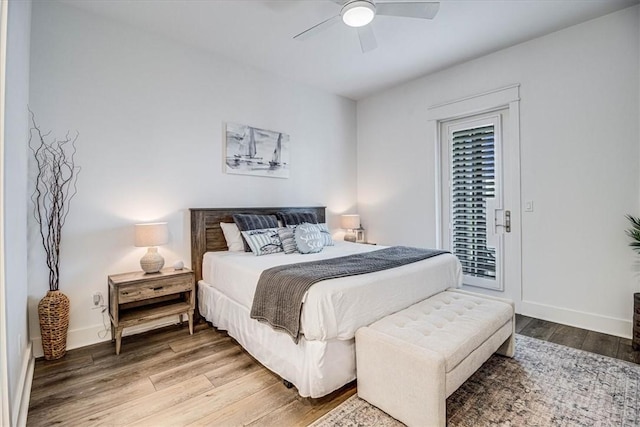 bedroom with access to exterior, a ceiling fan, baseboards, and wood finished floors