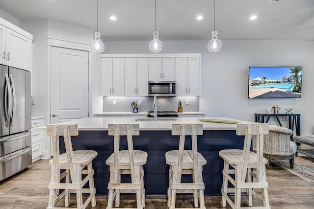 kitchen featuring light countertops, appliances with stainless steel finishes, and white cabinetry