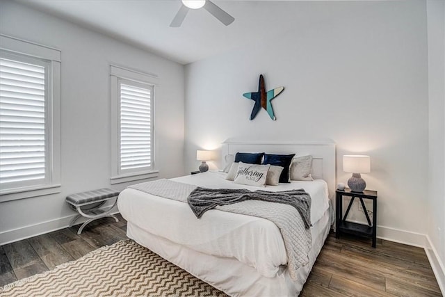 bedroom featuring dark wood-style floors, a ceiling fan, and baseboards