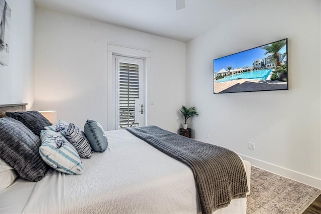 bedroom with a ceiling fan, access to outside, baseboards, and wood finished floors