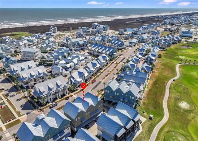 drone / aerial view featuring a water view, a beach view, and golf course view