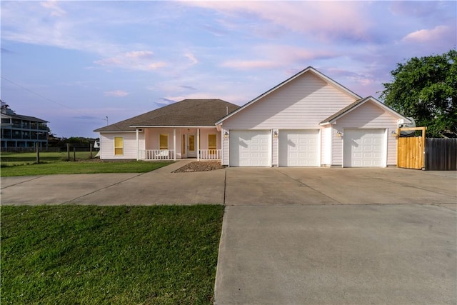 single story home with a garage, concrete driveway, fence, a porch, and a front yard