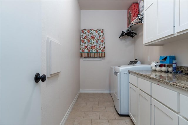 washroom with cabinet space, baseboards, and washer and dryer