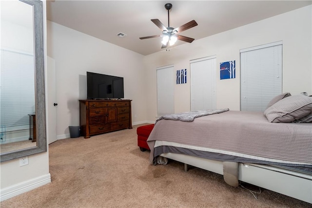 bedroom with baseboards, visible vents, a ceiling fan, and light colored carpet