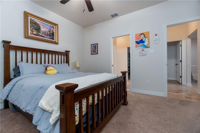 bedroom with baseboards, a ceiling fan, visible vents, and light colored carpet