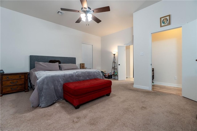 bedroom with light colored carpet, visible vents, vaulted ceiling, and ceiling fan